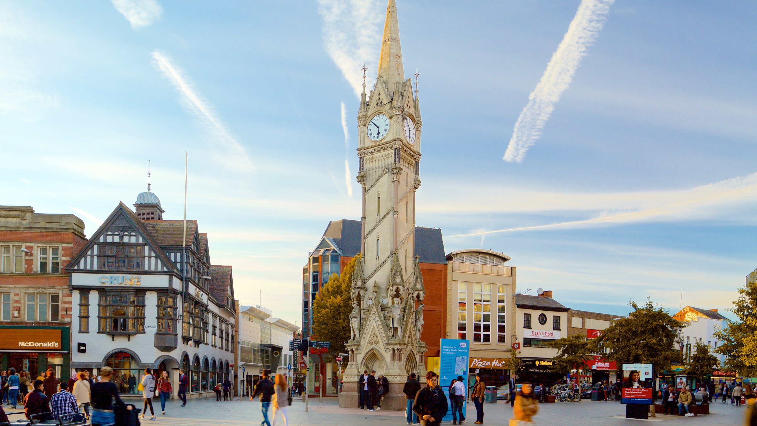 Clock tower in city centre square, blue sky.